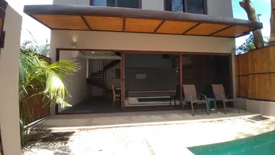 a house with a screened in porch with a patio at Green Turtle Townhome #1 Private Pool & Garden 300 Mtrs to Beach in Tamarindo