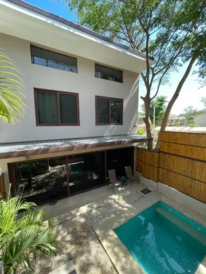 a house with a swimming pool in front of it at Green Turtle Townhome #1 Private Pool & Garden 300 Mtrs to Beach in Tamarindo