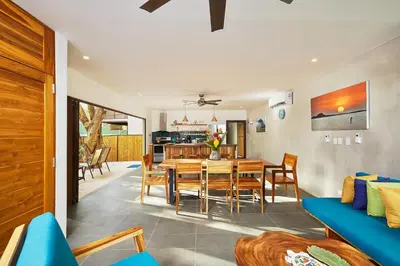 a dining room and living room with a table and chairs at New Beach House Walk to Tamarindo Beach & Town in Tamarindo