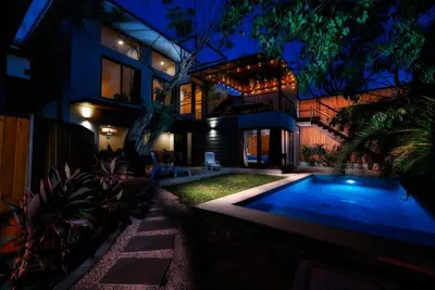 a house with a swimming pool at night at New Beach House Walk to Tamarindo Beach & Town in Tamarindo