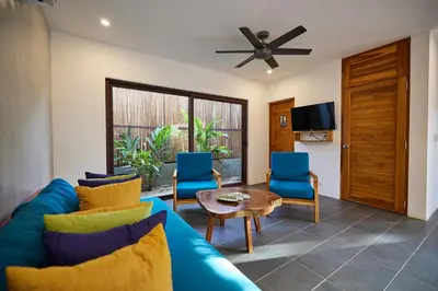 a living room with a blue couch and blue chairs at New Beach House Walk to Tamarindo Beach & Town in Tamarindo