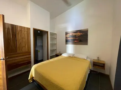 a bedroom with a bed with a yellow bedspread at 1Bedroom Apt wPool Walk to beach in Tamarindo