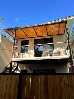 a house with a wooden fence in front of it at 1Bedroom Apt wPool Walk to beach in Tamarindo