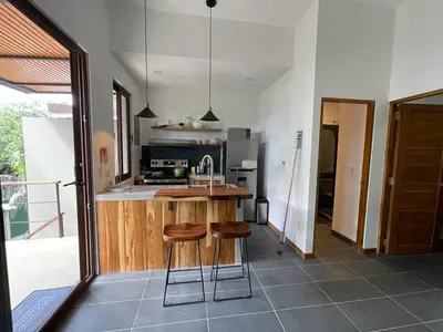 a kitchen with a counter and two stools in it at 1Bedroom Apt wPool Walk to beach in Tamarindo