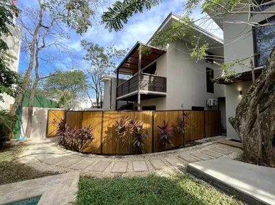a house with a wooden fence in front of it at 1Bedroom Apt wPool Walk to beach in Tamarindo