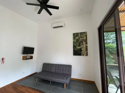 a living room with a couch and a ceiling fan at 1Bedroom Apt wPool Walk to beach in Tamarindo