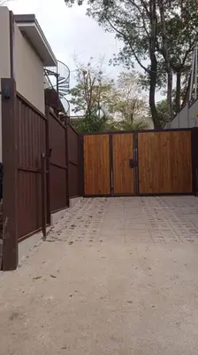 a driveway with a wooden fence next to a house at 1Bedroom Apt wPool Walk to beach in Tamarindo