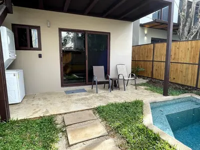 a patio with a table and chairs next to a house at Guest Studio Apt Pool 300m beach in Tamarindo