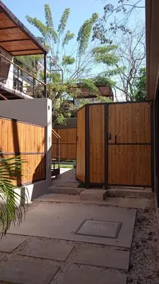 a wooden fence with a gate in a yard at Guest Studio Apt Pool 300m beach in Tamarindo