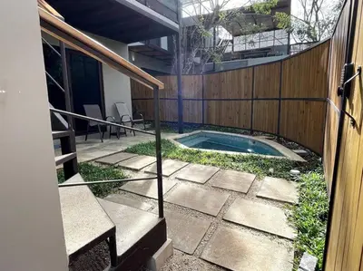 a swimming pool in a yard next to a fence at Guest Studio Apt Pool 300m beach in Tamarindo