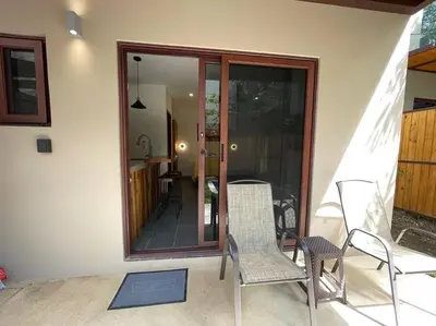a patio with two chairs and a sliding glass door at Guest Studio Apt Pool 300m beach in Tamarindo
