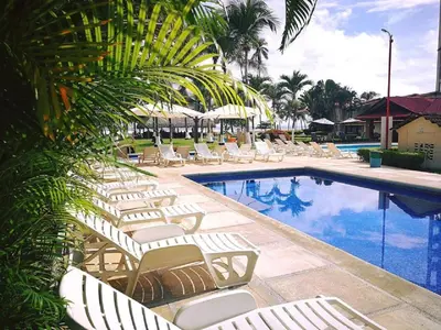 a group of lounge chairs and a swimming pool at Hotel & Villas Tangerí in Jacó