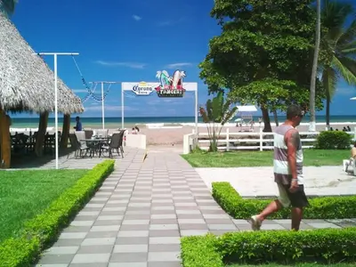 a man walking down a sidewalk near the beach at Hotel & Villas Tangerí in Jacó