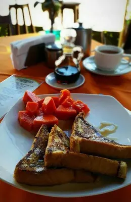 a plate of food with toast and fruit on a table at Hotel & Villas Tangerí in Jacó