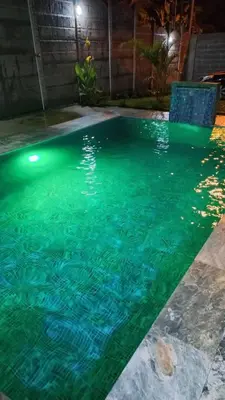 a swimming pool at night with green water at Casa Bahía Ale, Bahía Ballena Uvita in Uvita