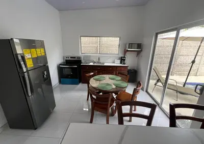 a kitchen with a table and a refrigerator at Casa Bahía Ale, Bahía Ballena Uvita in Uvita