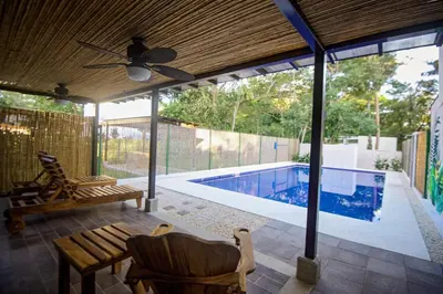 a patio with a swimming pool and a house at Amazing home with private pool & high-speed Wi-Fi! in Jacó