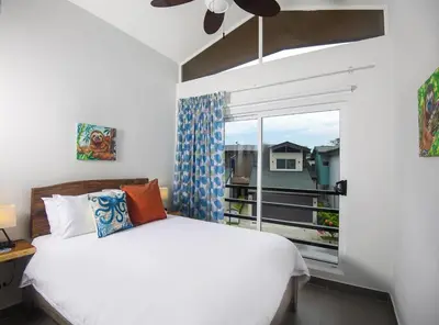 a bedroom with a white bed and a window at Amazing home with private pool & high-speed Wi-Fi! in Jacó
