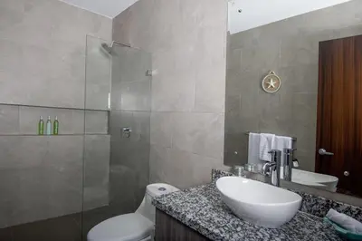 a bathroom with a sink and a toilet and a shower at Amazing home with private pool & high-speed Wi-Fi! in Jacó