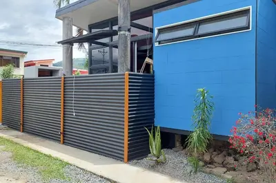 a blue house with a fence in front of it at Olly´s House in Turrialba