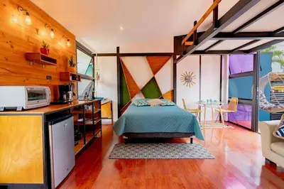 a bedroom with a bed in a room with a kitchen at Olly´s House in Turrialba