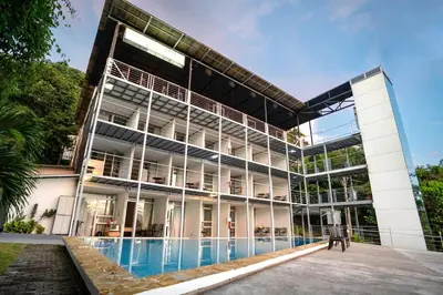 an external view of a building with a swimming pool at El Faro Containers Beach Hotel in Manuel Antonio