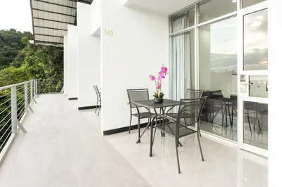 a balcony with a table and chairs on it at El Faro Containers Beach Hotel in Manuel Antonio
