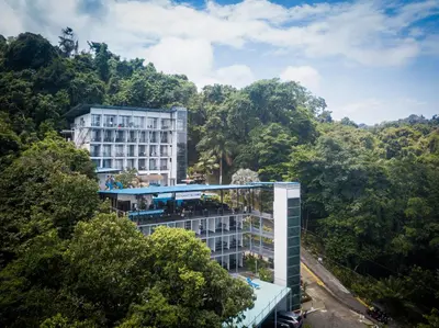 a building in the middle of the forest at El Faro Containers Beach Hotel in Manuel Antonio