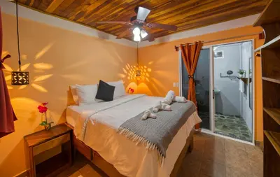 a bedroom with a bed and a ceiling fan at Jungles Edge Hotel, Jiu Jitsu, Muay Thai Retreat Center in Nosara