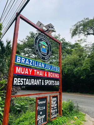 a sign for a monkey trial and boxing restaurant and sports bar at Jungles Edge Hotel, Jiu Jitsu, Muay Thai Retreat Center in Nosara