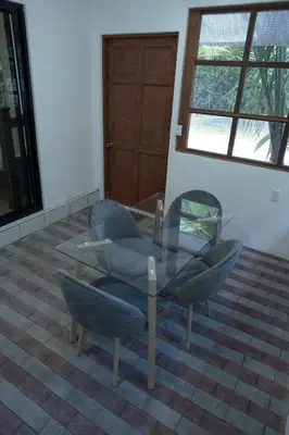a glass table and chairs in a room at Jungles Edge Hotel, Jiu Jitsu, Muay Thai Retreat Center in Nosara