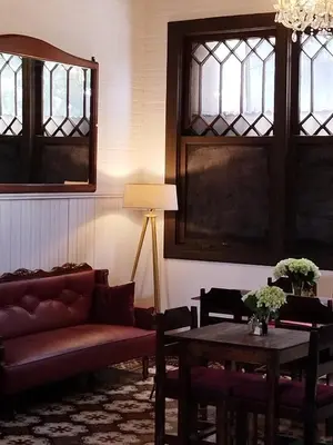 a living room with a couch and tables and windows at Casa Aldea Hotel Bed & Breakfast in San José