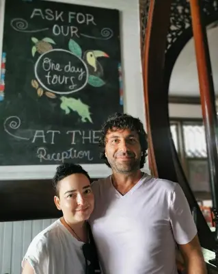 a man and a woman standing in front of a chalkboard at Casa Aldea Hotel Bed & Breakfast in San José