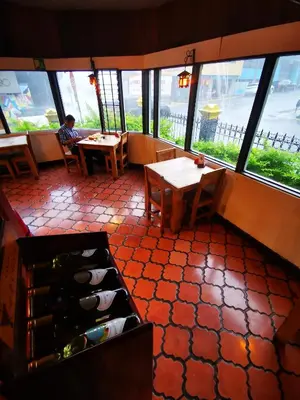 a restaurant with a person sitting at a table and windows at Casa Aldea Hotel Bed & Breakfast in San José