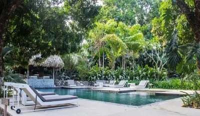 a pool with chaise lounge chairs and a swimming pool at Outsite Santa Teresa Maramar in Puntarenas