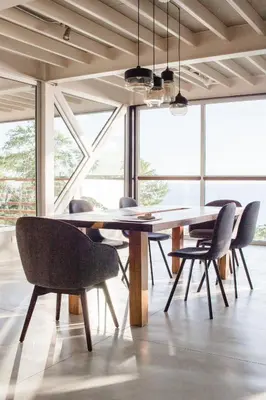 a table and chairs in a room with windows at Outsite Santa Teresa Maramar in Puntarenas