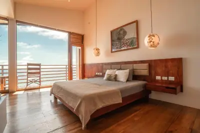a bedroom with a bed and a large window at Outsite Santa Teresa Maramar in Puntarenas