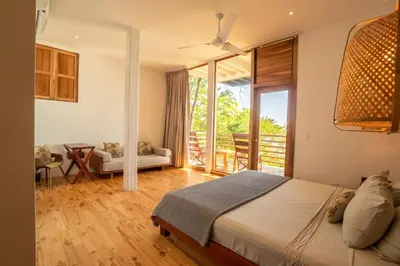a bedroom with a bed and a balcony at Outsite Santa Teresa Maramar in Puntarenas