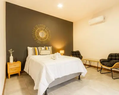 a bedroom with a large bed and two chairs at Casa Santa Fe Arenal Volcano in Fortuna