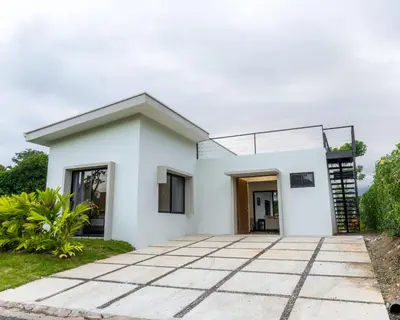 a white house with a pathway in front of it at Casa Santa Fe Arenal Volcano in Fortuna