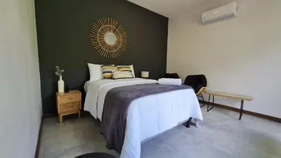 a bedroom with a bed and a mirror on the wall at Casa Santa Fe Arenal Volcano in Fortuna