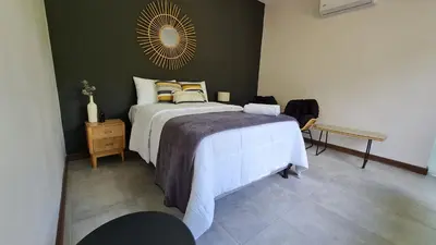 a bedroom with a bed and a mirror on the wall at Casa Santa Fe Arenal Volcano in Fortuna