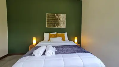 a bedroom with a large bed with towels on it at Casa Santa Fe Arenal Volcano in Fortuna