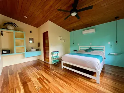 a bedroom with a bed and a ceiling fan at ChicoRico Studios in Uvita