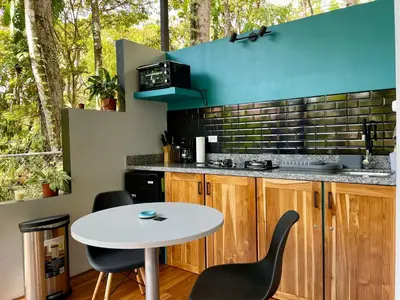 a kitchen with a table and two chairs and a counter at ChicoRico Studios in Uvita