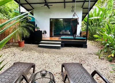 a patio with two chairs and a house at ChicoRico Studios in Uvita