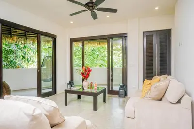a living room with two white couches and a table at Makara Resort 5 Bedrooms in Uvita