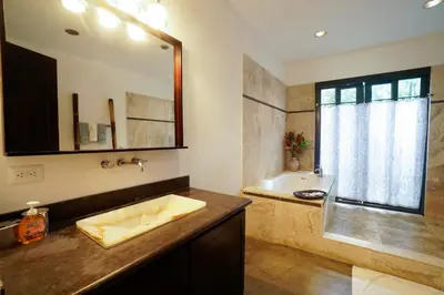 a bathroom with a sink and a large mirror at Makara Resort 5 Bedrooms in Uvita