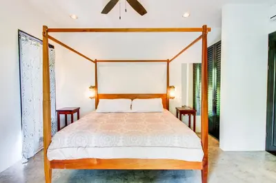 a bedroom with a four poster bed and two tables at Makara Resort 5 Bedrooms in Uvita