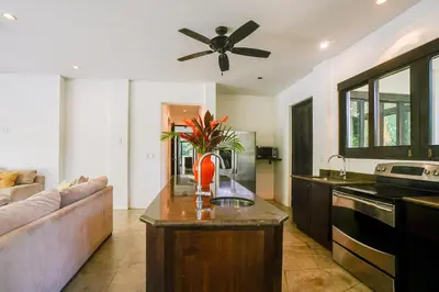 a kitchen with a couch and a ceiling fan at Makara Resort 5 Bedrooms in Uvita